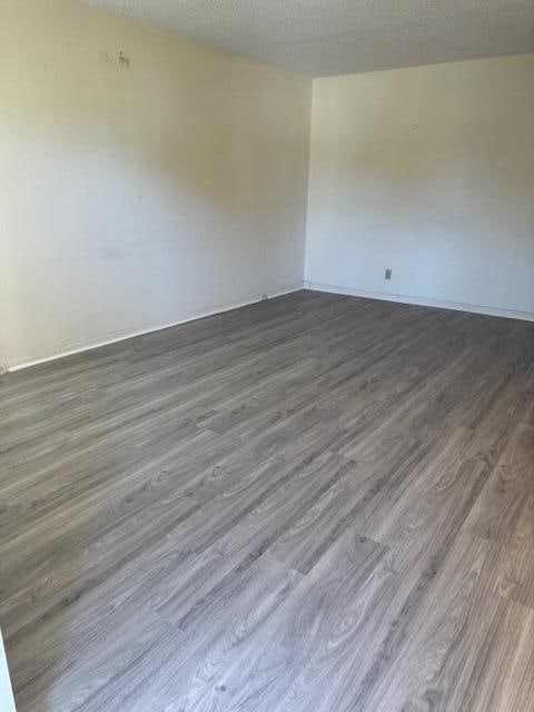 unfurnished room featuring dark hardwood / wood-style floors and a textured ceiling