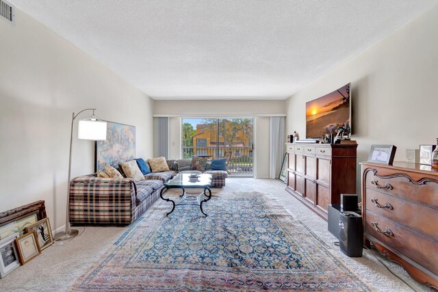 carpeted living room featuring a textured ceiling