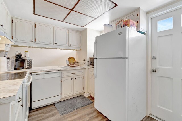 kitchen with white cabinets, white appliances, and light hardwood / wood-style flooring