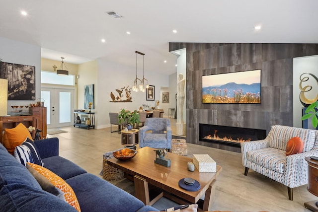 living area featuring recessed lighting, visible vents, a fireplace, and french doors