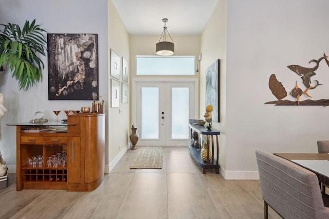 foyer entrance with french doors and baseboards