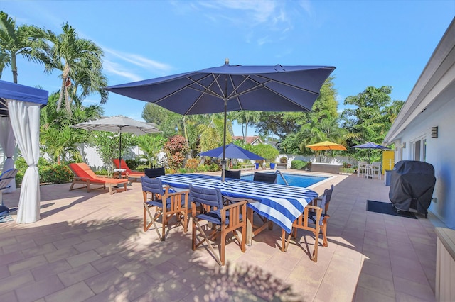 view of patio with an outdoor pool, grilling area, outdoor dining space, and fence