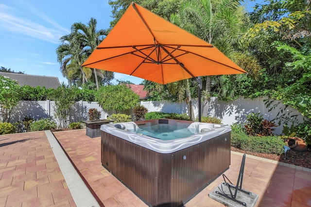 view of patio / terrace featuring a hot tub and a fenced backyard