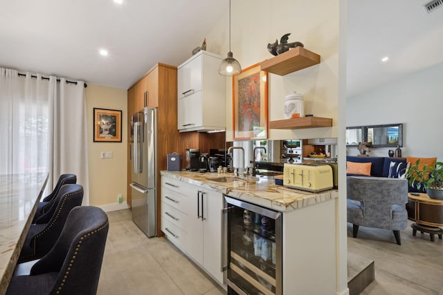 kitchen with open shelves, freestanding refrigerator, wine cooler, white cabinetry, and decorative light fixtures