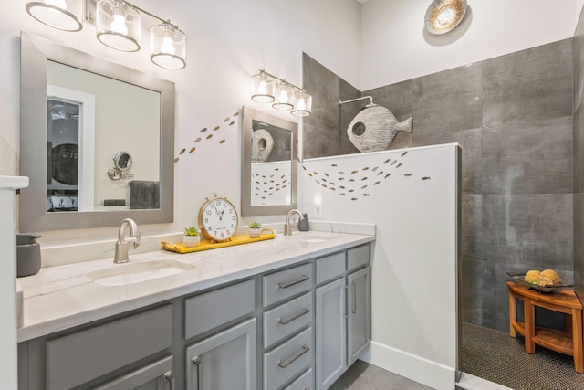 bathroom featuring double vanity, walk in shower, tile patterned floors, and a sink