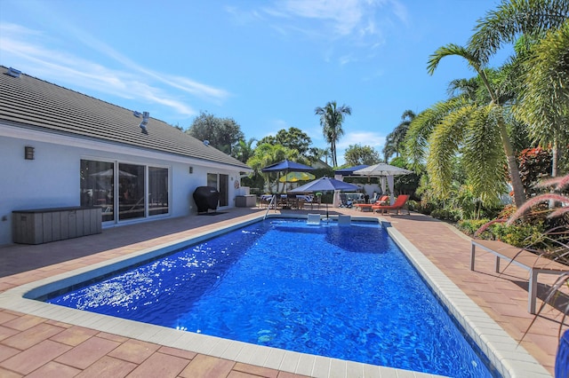 view of swimming pool featuring a patio area, a fenced in pool, and a grill