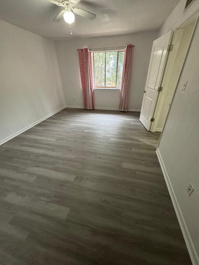 empty room featuring ceiling fan and dark hardwood / wood-style floors