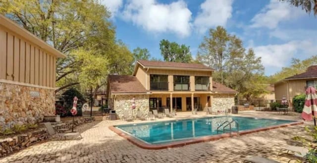 rear view of house with a patio and a community pool