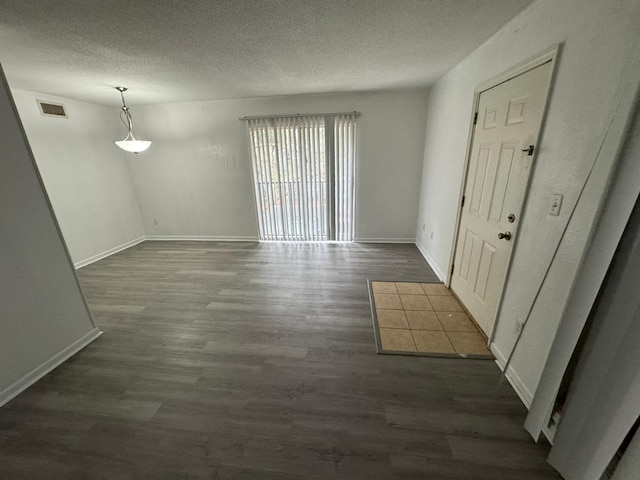 spare room with dark hardwood / wood-style flooring and a textured ceiling