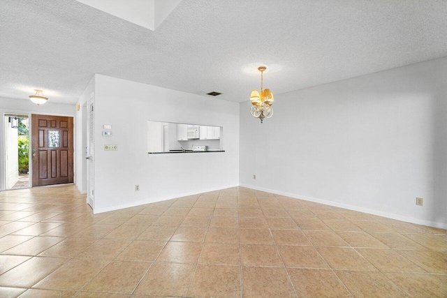 unfurnished living room featuring light tile patterned floors, a textured ceiling, and an inviting chandelier