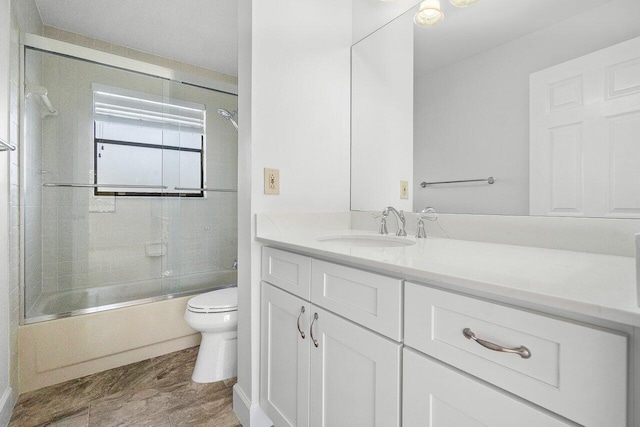 full bathroom featuring vanity, toilet, and enclosed tub / shower combo