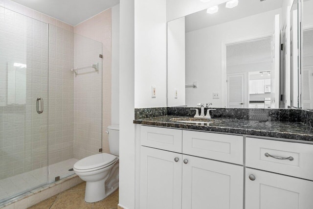 bathroom with tile patterned flooring, vanity, toilet, and a shower with door