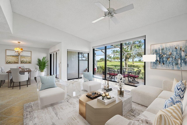 living room featuring ceiling fan with notable chandelier, lofted ceiling, and a textured ceiling