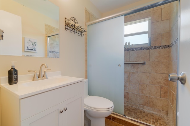 bathroom with vanity, toilet, and a shower with door