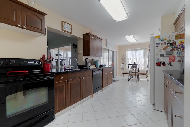 kitchen with light tile patterned flooring, dark brown cabinets, sink, and black appliances