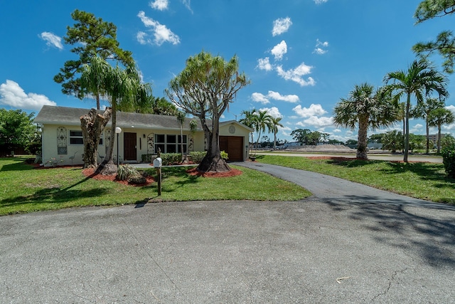 ranch-style house featuring a garage and a front yard