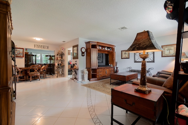 living room with a textured ceiling and light tile patterned floors