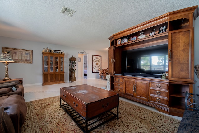 living room featuring light tile patterned floors and a textured ceiling