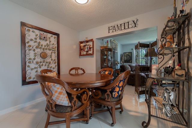 dining area with light tile patterned flooring and a textured ceiling