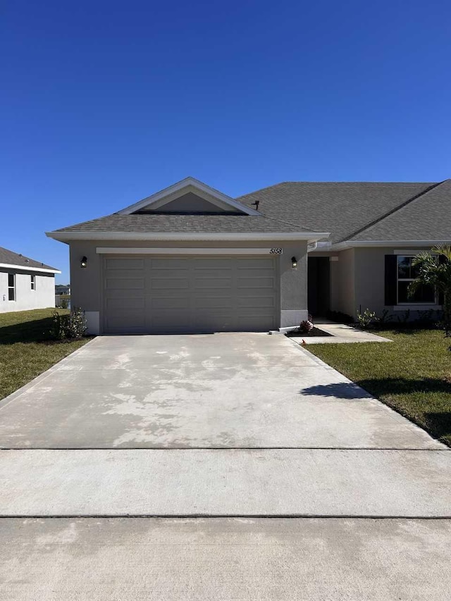 single story home with a front yard and a garage