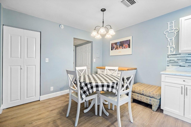 dining space featuring an inviting chandelier and light hardwood / wood-style floors