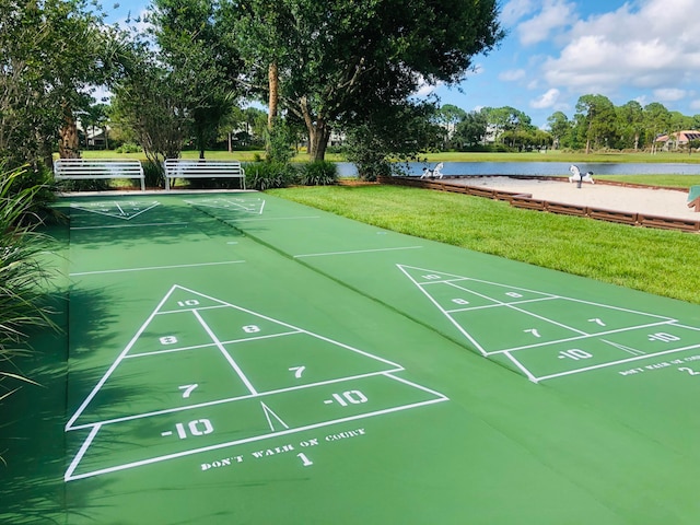 view of property's community with a yard and a water view