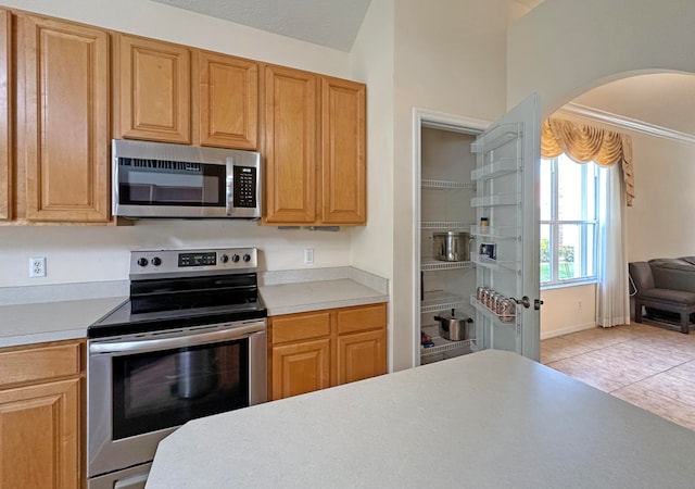 kitchen featuring stainless steel appliances and light tile patterned flooring