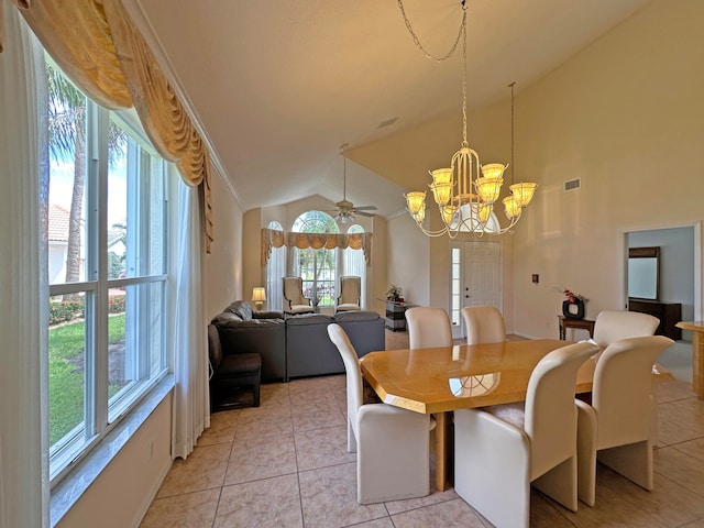 tiled dining space featuring ceiling fan with notable chandelier, lofted ceiling, and a healthy amount of sunlight