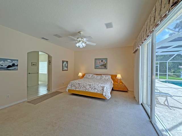 bedroom featuring ceiling fan, a textured ceiling, light carpet, and access to outside