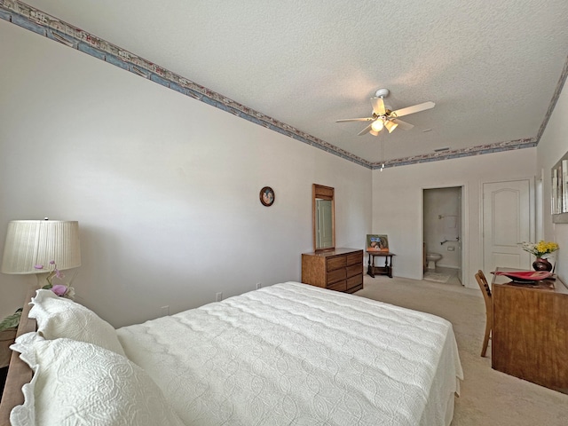 bedroom featuring light carpet, connected bathroom, ceiling fan, and a textured ceiling