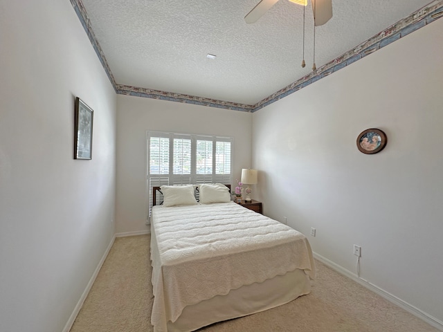 bedroom featuring light carpet, ceiling fan, and a textured ceiling