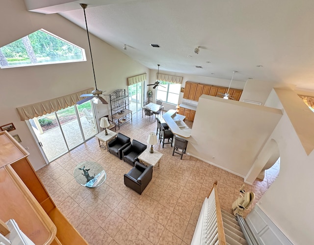 living room with ceiling fan, light tile patterned flooring, and high vaulted ceiling