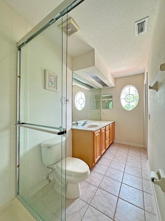 bathroom featuring vanity, a textured ceiling, an enclosed shower, toilet, and tile patterned floors