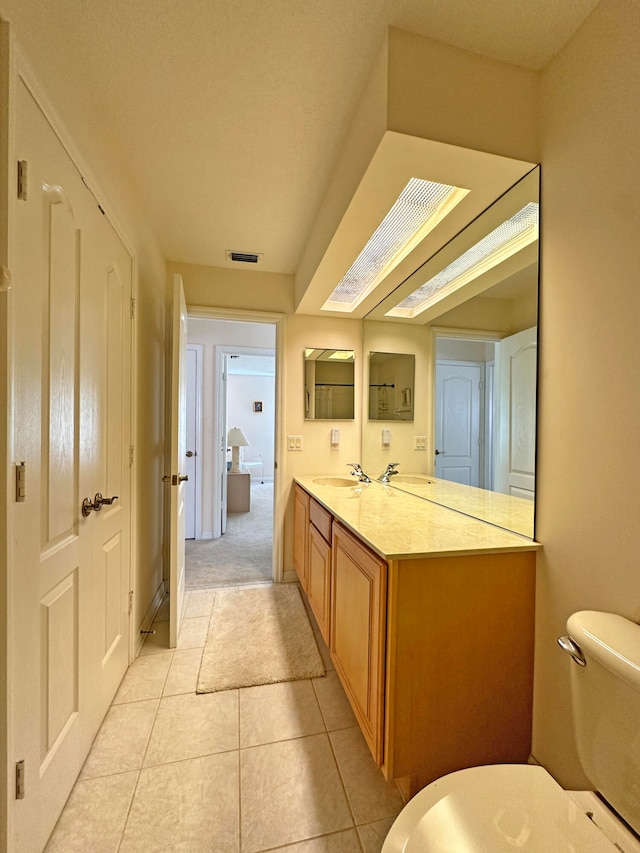 bathroom with vanity, toilet, and tile patterned floors