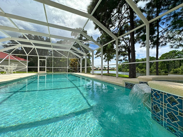 view of pool featuring glass enclosure, pool water feature, and a patio area