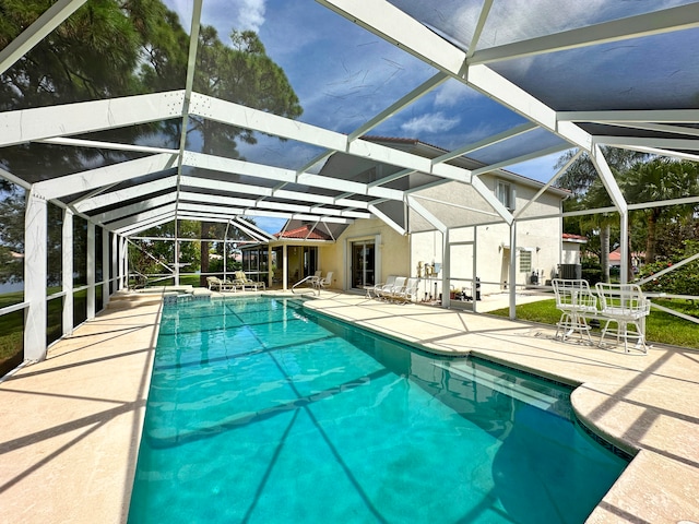 view of pool featuring glass enclosure and a patio area