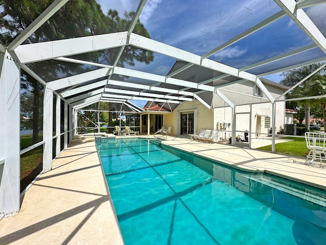 view of pool with glass enclosure and a patio