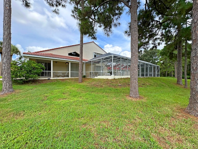 rear view of house featuring a yard and a lanai