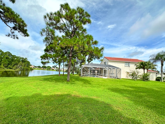 view of yard with glass enclosure and a water view