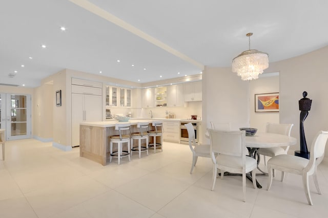 tiled dining space with sink and a chandelier