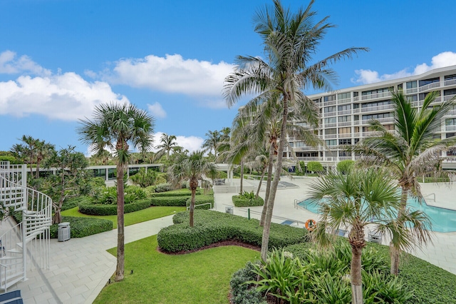 view of property's community featuring a lawn and a swimming pool