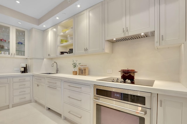 kitchen with white cabinetry, black electric cooktop, stainless steel oven, and sink