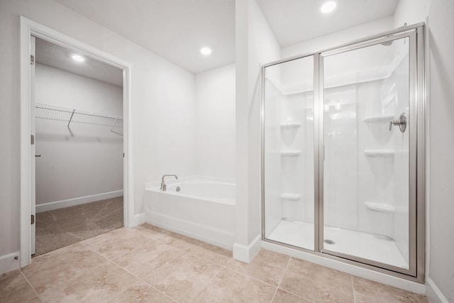 bathroom featuring tile patterned flooring and shower with separate bathtub