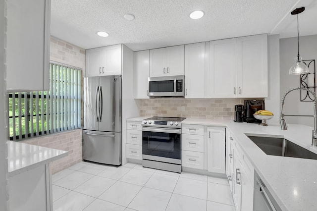 kitchen featuring pendant lighting, white cabinetry, appliances with stainless steel finishes, and sink