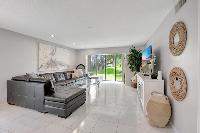 living room featuring a textured ceiling and light tile patterned floors