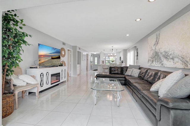 tiled living room featuring a notable chandelier