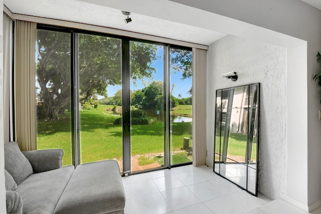 doorway featuring a wealth of natural light, a water view, light tile patterned flooring, and expansive windows