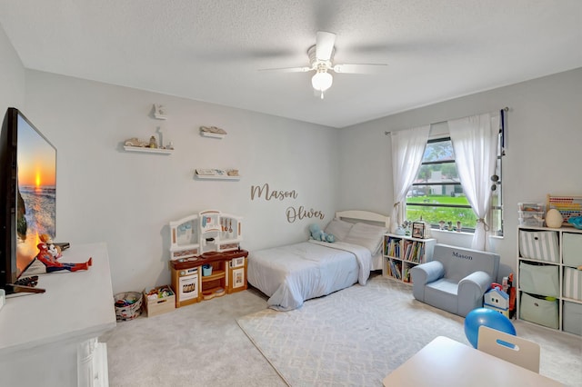 bedroom featuring ceiling fan, a textured ceiling, and carpet flooring