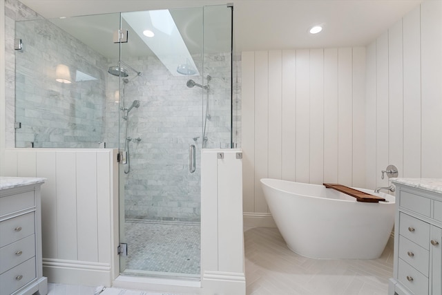 bathroom featuring a stall shower, vanity, a freestanding bath, and recessed lighting