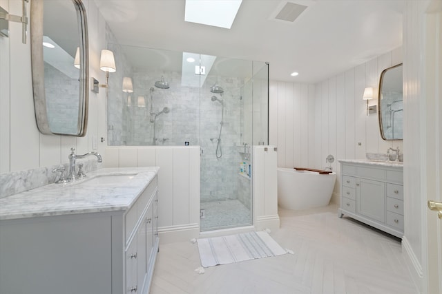 bathroom with a skylight, vanity, shower with separate bathtub, and tile patterned flooring